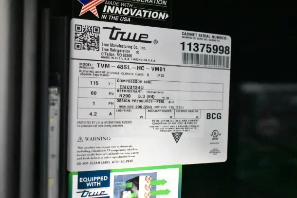 "True TVM-48SL-HC cooler label shows serial number 11375998, 115V, 1 phase, refrigerant R290, and safety warnings."