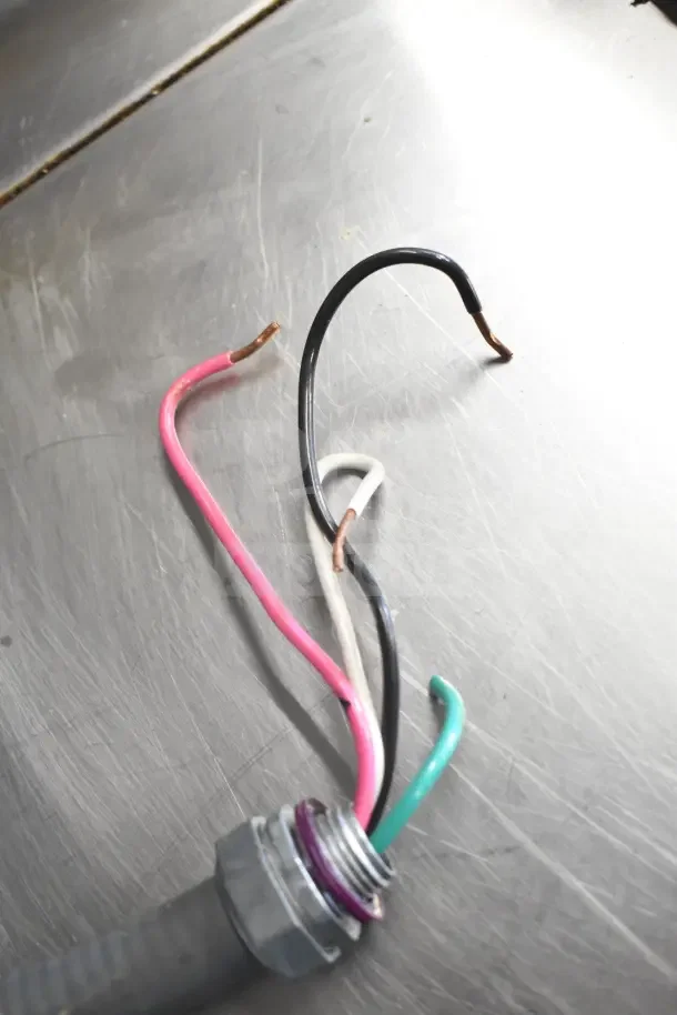 Loose electrical wires on a metal surface; part of a Groen BPM-15EC commercial braising pan setup.