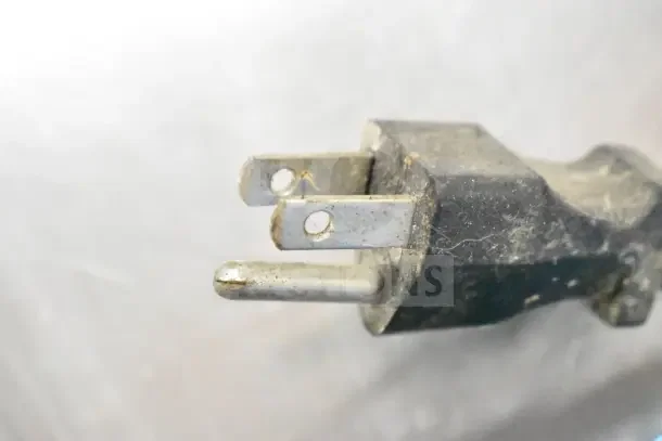 Close-up of a worn two-prong electrical plug, part of the Broaster 1800 gas-powered pressure fryer, showing minor wear.