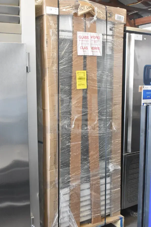 Brand new 2026 True TSCI-600R-G-PH single door cooler merchandiser, wrapped on pallet, 115 volts, labels indicating glass content.
