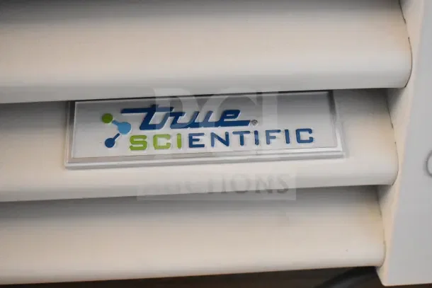 "True Scientific" logo on a panel of the True TSCI-600R-G-PH cooler merchandiser, showing brand detail.