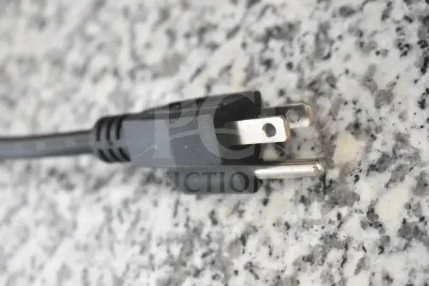 Close-up of a plug on granite surface, indicating the KoolMore KM-RPPS-2D59-GRT's electricity requirements.