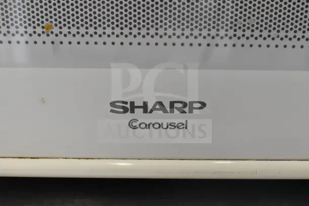 Sharp R-309YW Countertop Microwave Oven, 120V, featuring a Carousel turntable and white finish, visible logo and vent pattern.