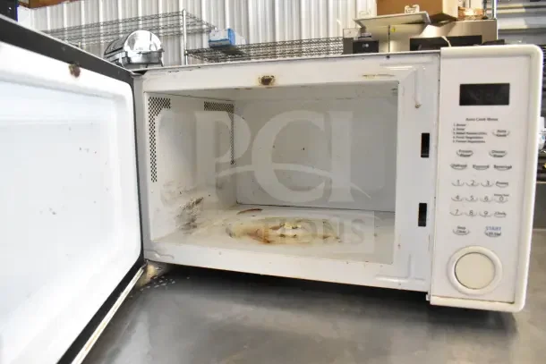 Sharp R-309YW countertop microwave, 120 volts, visible interior wear, includes control panel with preset buttons.