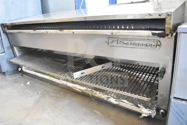 Southbend gas-powered cheese melter with visible branding. Metal grates, signs of wear. Suitable for commercial kitchens.