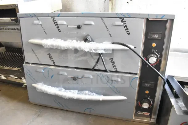 Brand new ServIt 423WDSFS2 commercial double drawer warmer. Visible protective film, 120 volts, 1 phase, slight dents.