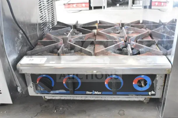 Star Max Commercial 4 Burner Gas Range, used condition with visible wear. Features easy-to-use control knobs.
