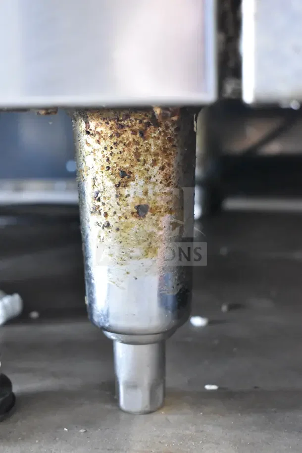 Standex 24GFGV4B20N commercial gas range, showing a close-up of a leg with visible wear and rust details.