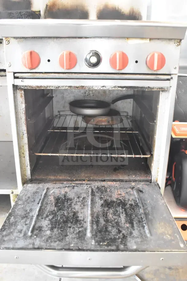 Standex 24GFGV4B20N commercial gas range with four burners, oven, overshelf, and backsplash. Used condition.