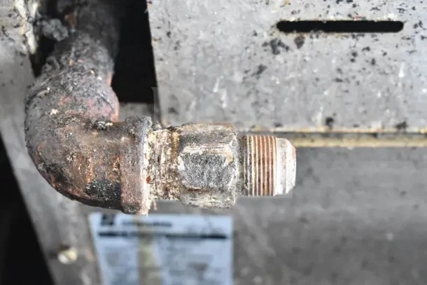 Rusty gas connection on Standex 24GFGV4B20N commercial range. Worn condition visible. Model label slightly obscured.