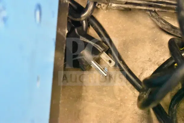 Electrical plug and cords of a 2025 KoolMore KM-CTCO-23STI countertop convection oven, shown in a storage area.