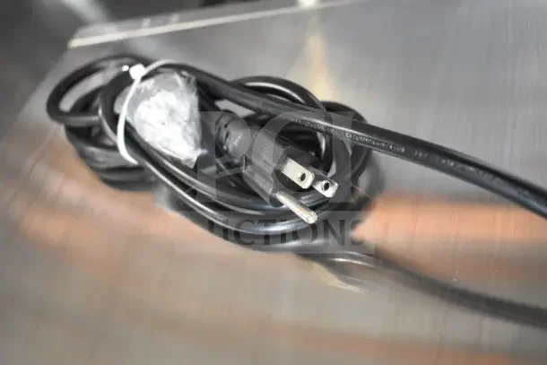 Coiled black power cord for 2025 KoolMore SCDC-6P-SSL refrigerated countertop condiment station, resting on metal surface.
