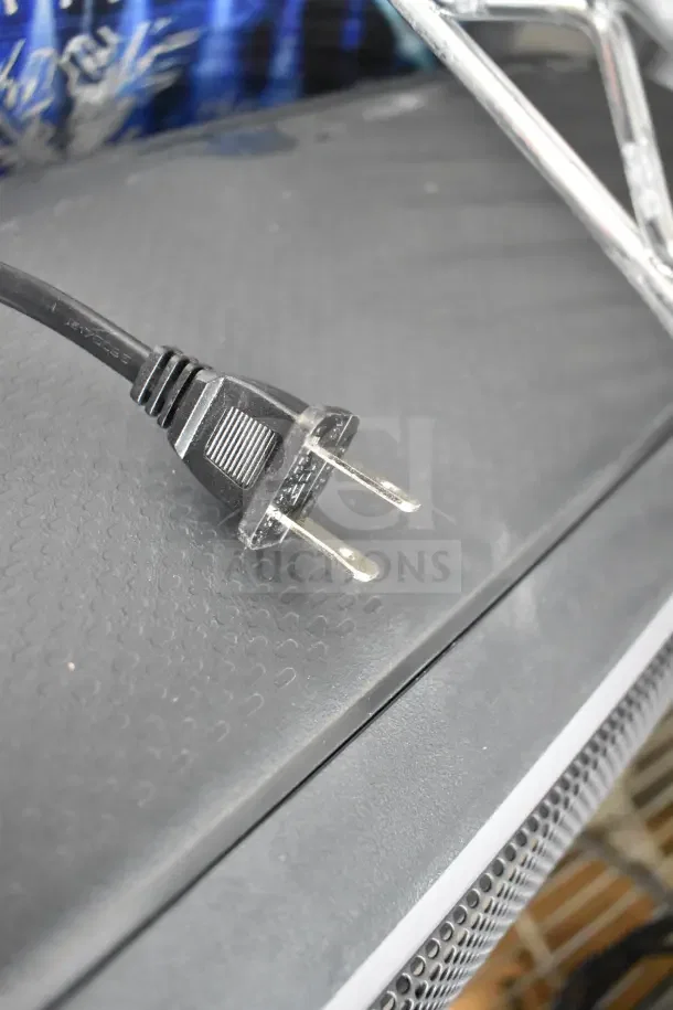 Onn Large Party Speaker with black power cord on display, textured black surface, and metal grille detailing.
