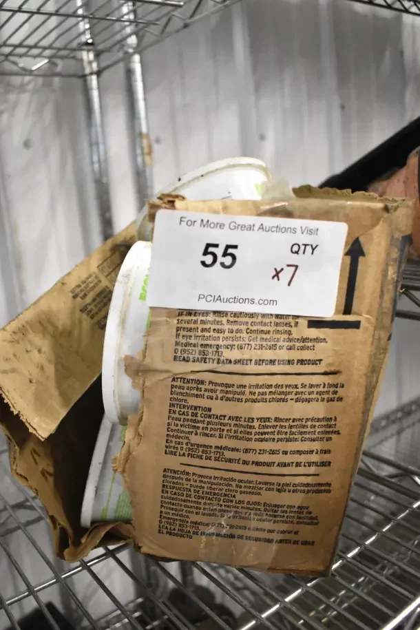 Seven Lime-a-way solid cleaner bins on a metal shelf, bundled in cardboard. Label reads "55 QTY x7" from PCI Auctions.