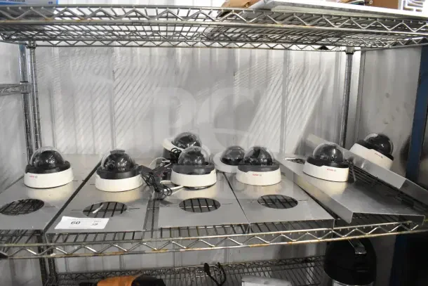8 Bosch Flexidome IP Indoor 5000 HD security cameras on shelf, black and white design, appear in good condition.