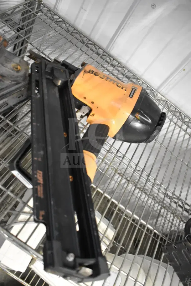 Two Bostitch F33PT Framing Nailers, shown on a metal shelf, featuring orange and black design. Good condition.