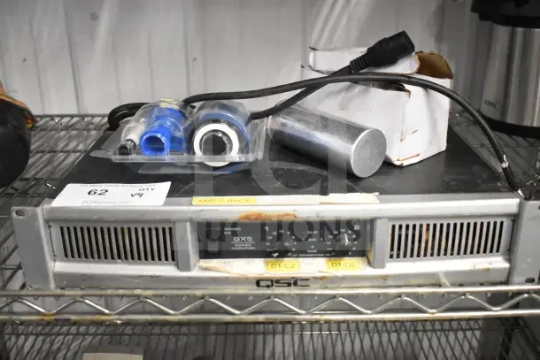 QSC GX5 power amplifier with visible wear, Fargo DTC color ribbon, D98LTB-50 on wire shelf, auction item tag "62 QTY V4".