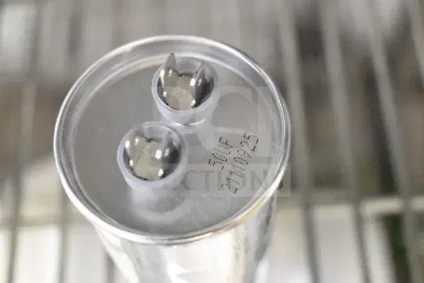 Top view of a metallic item with two connector terminals. Marked "50UF 2419025" indicating specifications.