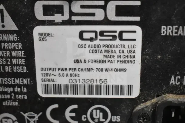 QSC GX5 Power Amplifier label showing model, serial number 031328156, power output, and compliance markings.