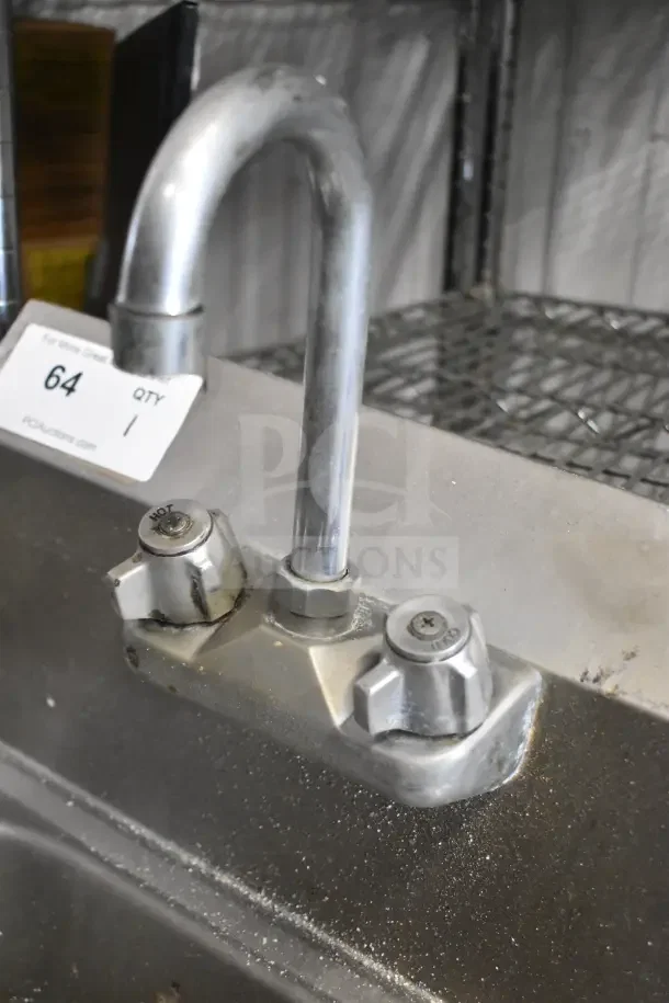 Commercial single bay sink with faucet and handles, stainless steel, visible "Hot" marking, tag indicates auction item 64.