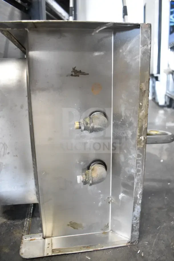 Commercial single bay sink with faucet and handles, stainless steel, wear and oxidation marks, sturdy construction.