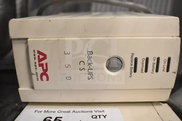 Two APC Back UPS CS 350 units, featuring status lights and power button. Visible wear on casing. Auction lot includes both units.