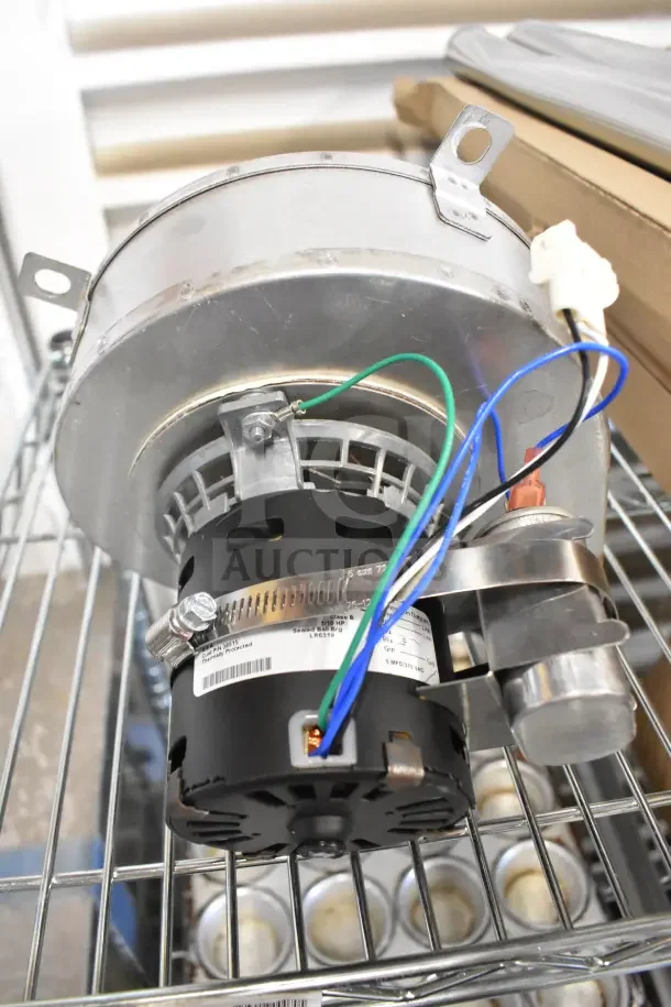 Motor unit with wires and metal casing, labeled 21TG2KR0V22, in good condition on metal shelf.