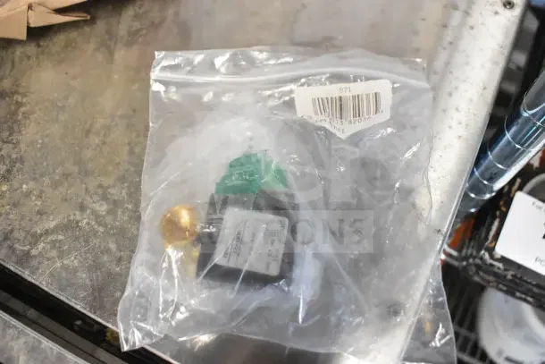 Sealed plastic bag with Motor and 21TG2KR0V22 unit, labeled with barcode 871, on metal surface.