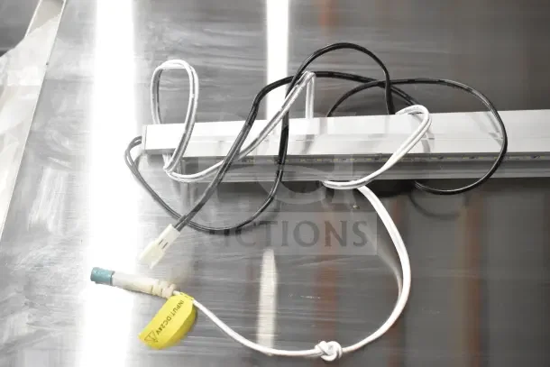 Two LED light strips with wires, connectors, and yellow "Input: 24V" tag, on a metallic surface.