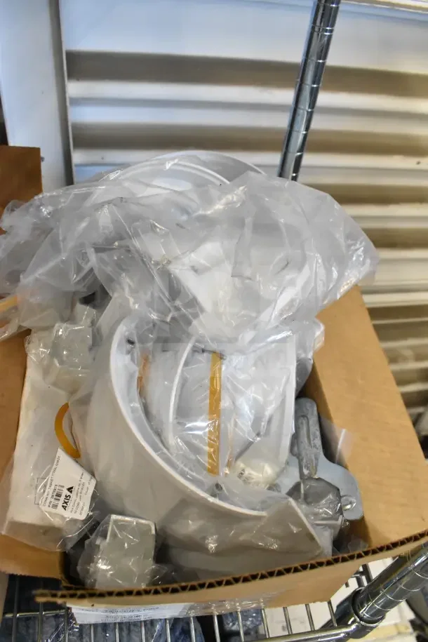 Two boxes of Wren camera mounts in new condition, sealed in plastic, featuring multiple metal brackets and labeled with "Axis".