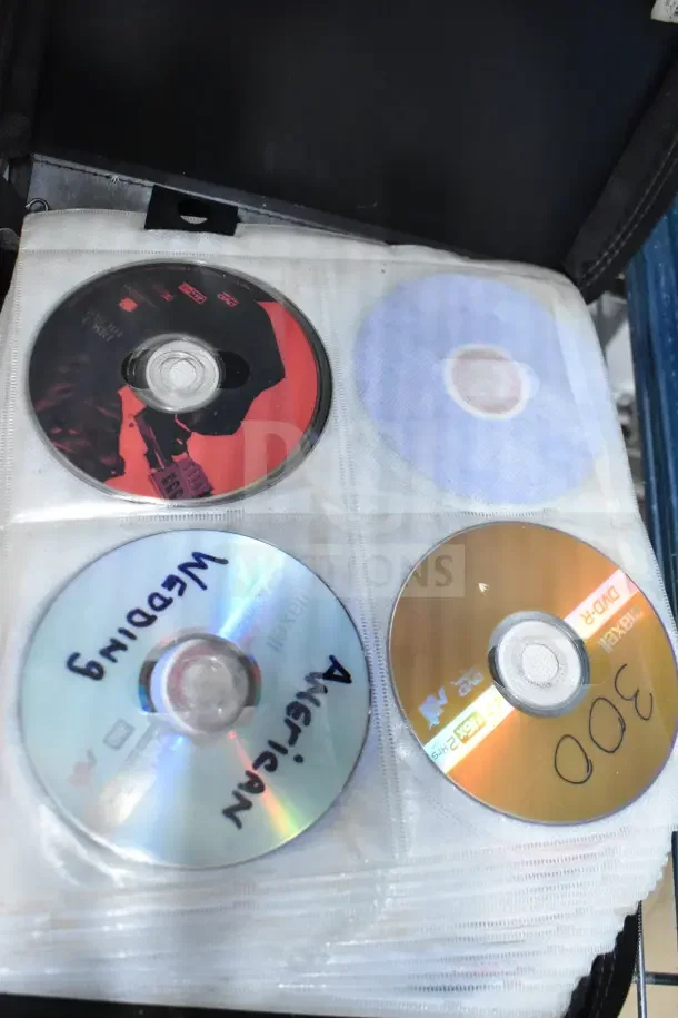 CD binder with assorted DVDs, includes titles "Wedding" and "300". Binder and discs in used but good condition.