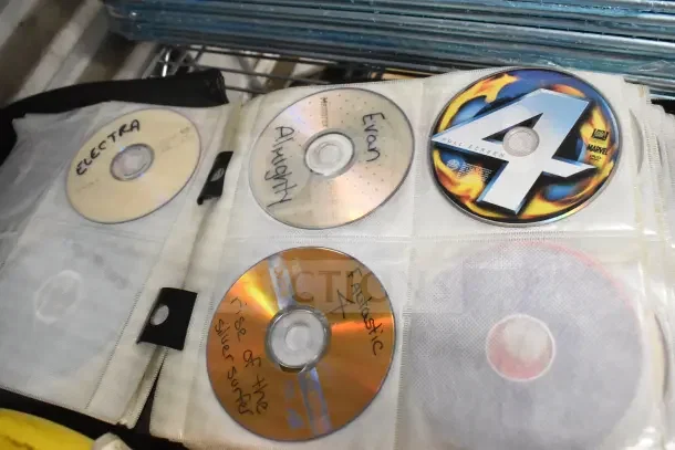 CD binder with multiple discs including handwritten labels like "Electra" and "Almighty" and a "Fantastic Four" DVD. Item in good condition.