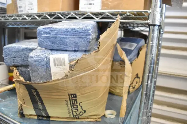 22 brand new mop heads sealed in plastic, packed in partially open cardboard box labeled "Bison," on metal shelf.