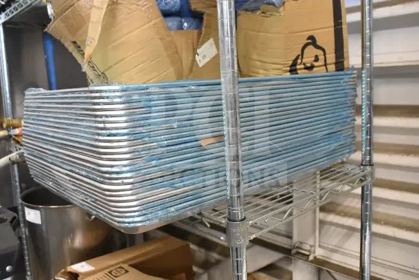24 brand new full-size baking sheets, scratch and dent condition, stacked on a metal shelf.