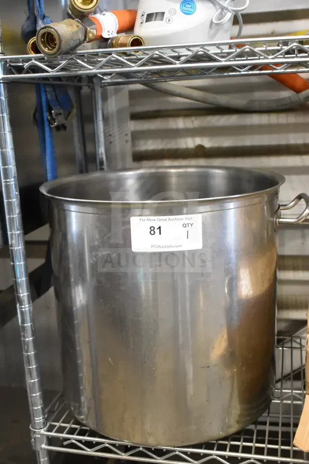 Stainless steel stock pot with handles on a metal shelf. Label reads "PCI Auctions, Item 81, Qty 1." Used condition.
