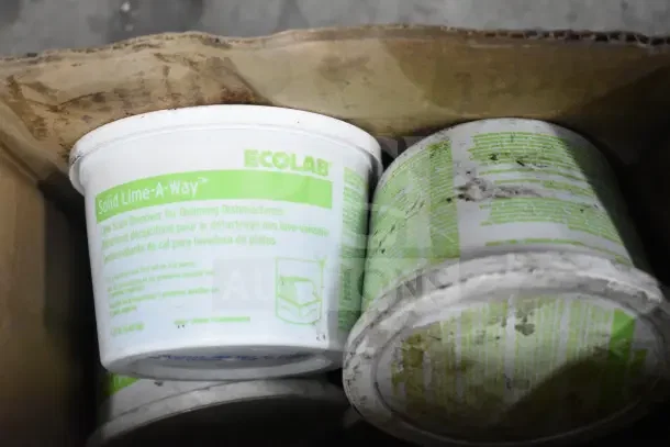 Two containers of Ecolab Solid Lime-a-Way scale remover, visible labels, cardboard box. Condition fair, some wear.