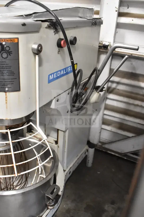 Hobart Medalist commercial dough mixer, floor style, with bowl, whisk attachment, and bowl guard. 115 volts, visible wear.
