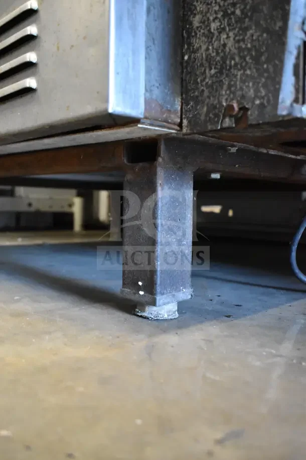 Vulcan full-size convection oven detail, highlighting the sturdy metal leg and oxidized surface, indicating used condition.