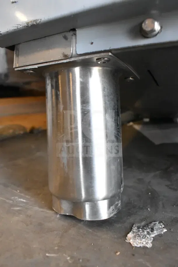 Close-up of the stainless steel leg of a Mainstreet 541HTDT401 dish machine, showing minor scratches and dents.