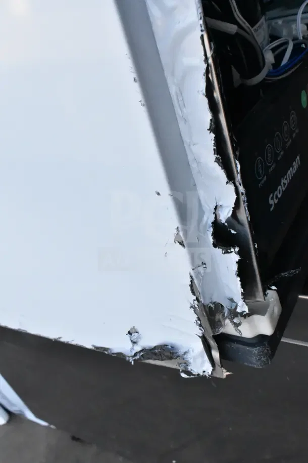 BRAND NEW Scotsman MC0330MAX-1A ice machine, 365 lb capacity, visible dent and scratches on the side panel.