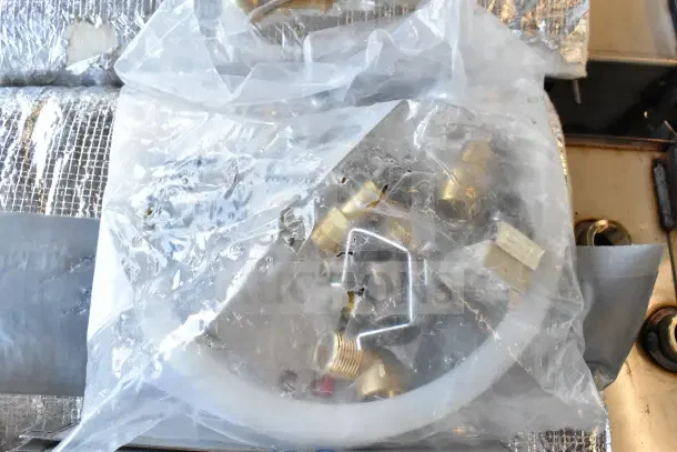 Bag of various brass fittings and connectors, sealed in clear plastic, suitable for plumbing or mechanical use.