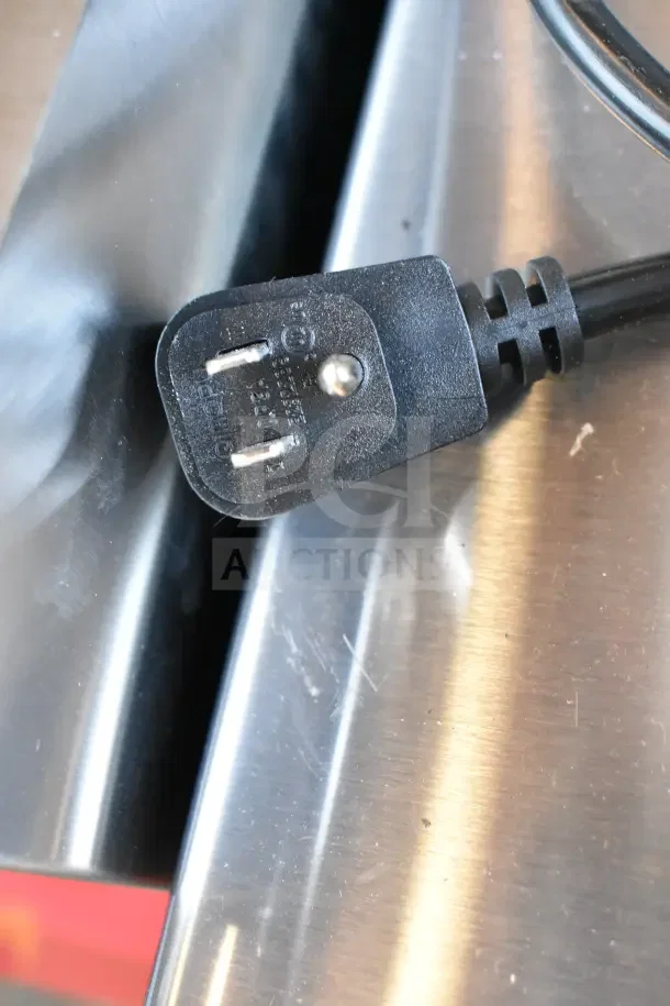 Close-up of a power plug attached to a new Amana RCS10TS commercial microwave, showing the 120 Volt specification.