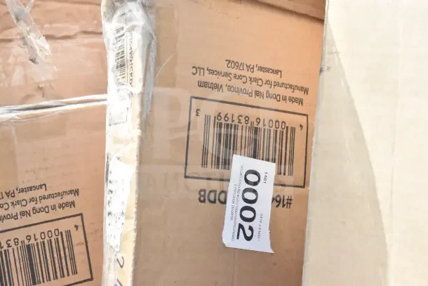 Cardboard boxes with barcode and label, indicating 28 brand new scratch and dent items including a chair and hole punch.
