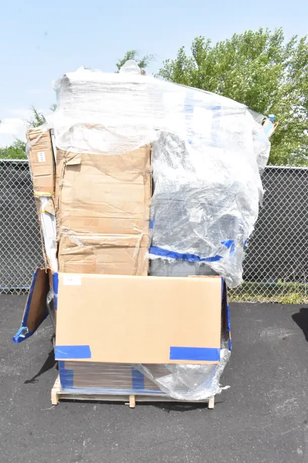 Large stack of boxed items on a pallet, wrapped in plastic. Includes brand new, scratch and dent tables. Visible label reads “126.”