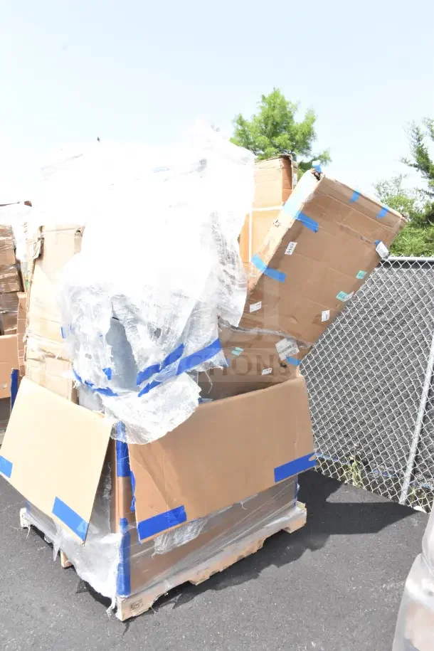 Pallet with 12 assorted scratch and dent items, including tables, in large partially open cardboard boxes.