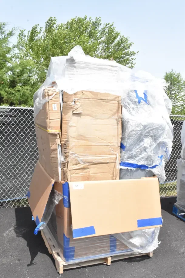 Pallet of 12 brand new scratch and dent items, including tables, in original packaging with visible damage.