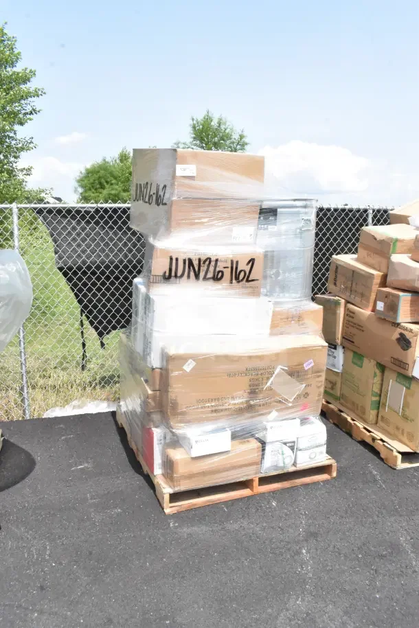 Stack of boxes containing 36 new scratch and dent items, including plates and glasses, marked "JUN26-162," on a pallet.
