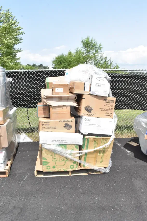 Assorted boxes of 28 new scratch and dent items, including hot cups, spoons, and appetizer cups, on a pallet outdoors.