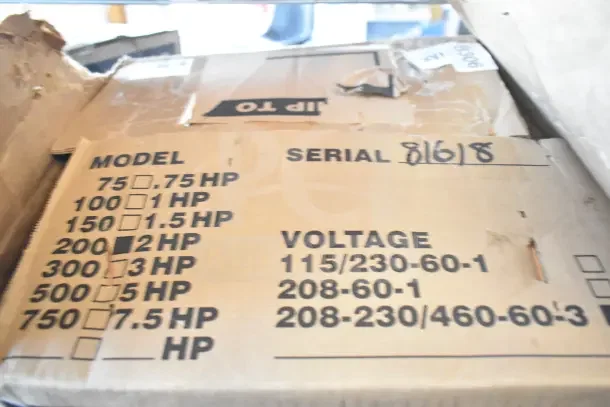 Cardboard box showing Insinkerator 200 Garbage Disposal details, including model as 2 HP and serial number 81618.