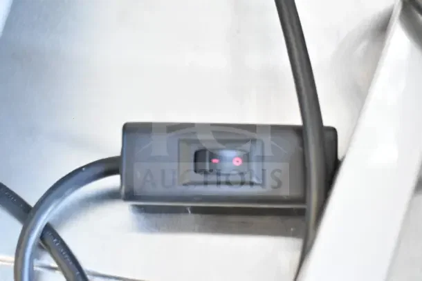 Switch of Nemco 6016 Carving Station, 120V, 1 Phase. Black plastic with red indicator on metal surface.